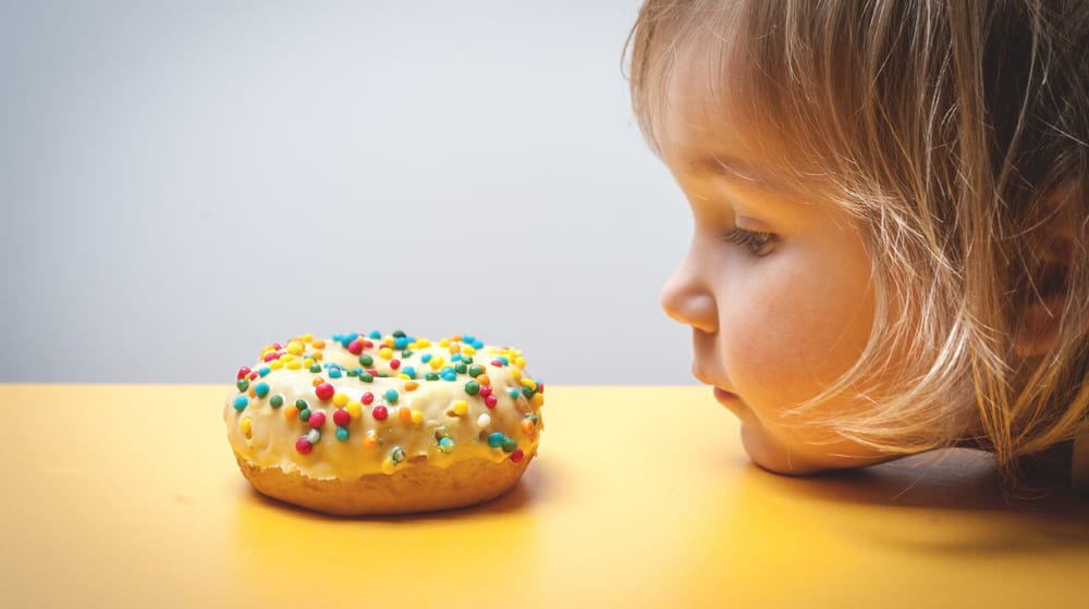 little kid staring on a donut | STUDY: Brain Differences in Kids May be Tied to Obesity | featured