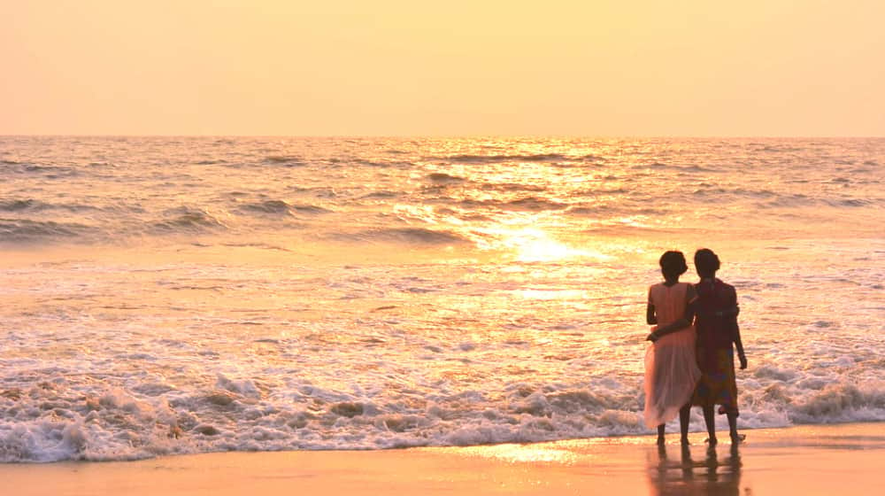 Two women on shoreline during sunset | A Better Approach to Life Expectancy