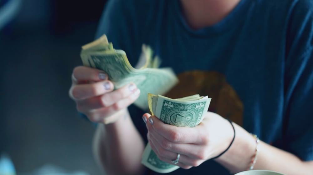 lady counting money | 6 Resolution Ideas for a New You in 2020 