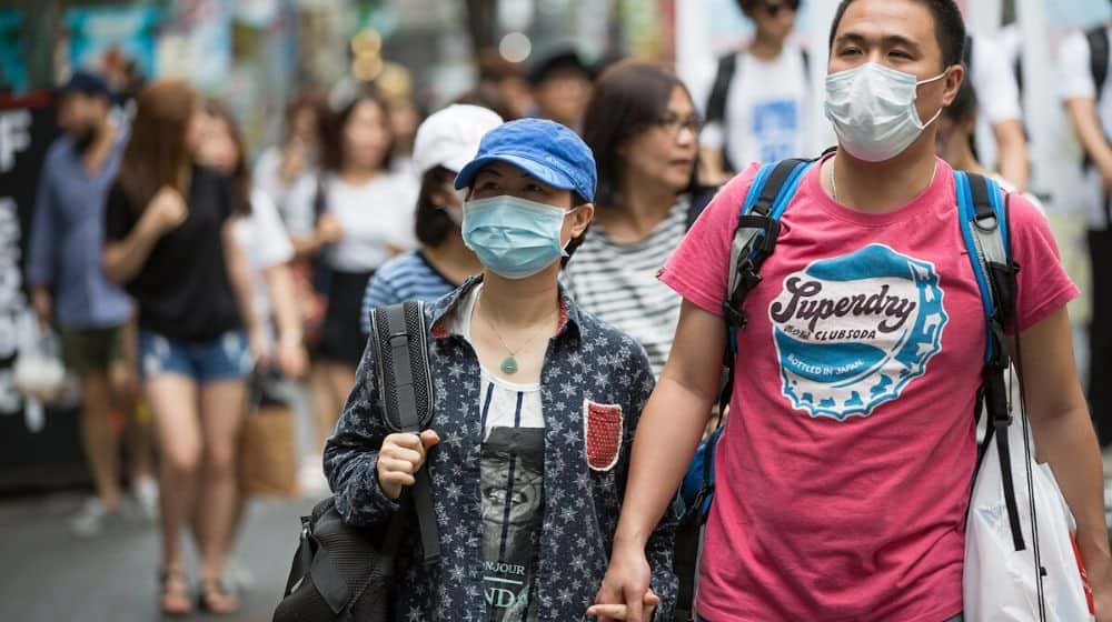 couple wearing mask | Coronavirus: 56 Dead and 1,975 Infected as Canada Reports 1st Case | Featured