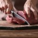 man cutting a pork meat | Meat Alternatives Have Gone Mainstream, But How Can They Fit in Your Diet? | Featured