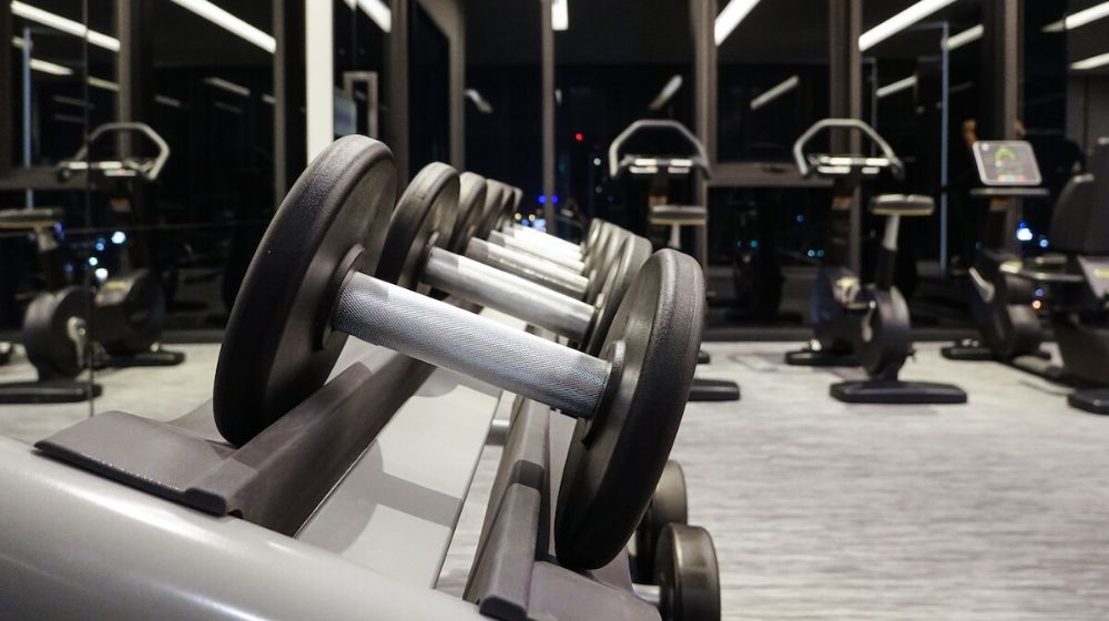 Dumbbells in the gym | Dumbbells on the steel rack in the gym and modern fitness center | Featured