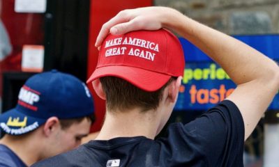 Two young men wearing Make America Great Again | Anonymous Group Releases Pigeons in MAGA Hats During Democratic Debate | Featured