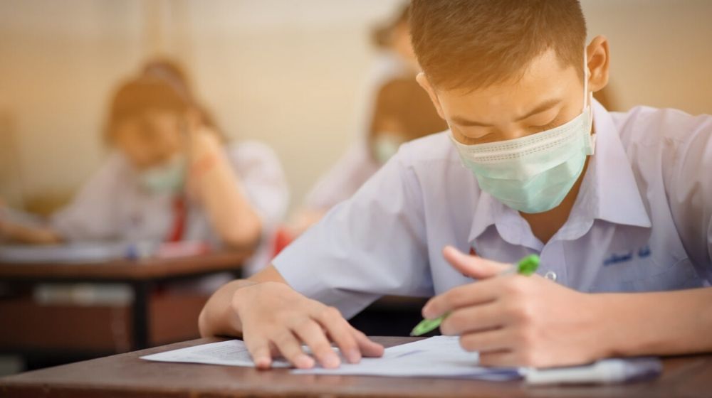 asian student at school wearing face mask | Many Schools Have Closed ― But Not All. What Parents Need To Know About That Tough Call| Featured