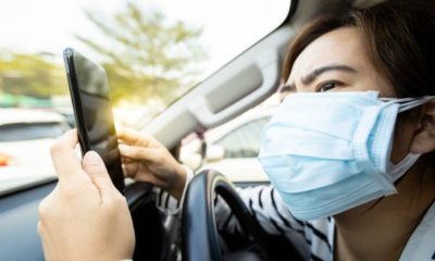 woman wearing a mask insider her car | Woman Licks Plane Toilet Seat for the “Coronavirus Challenge” and Gets Slammed by Twitter | Featured