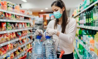 woman getting water in the supermarket | Fact Check: A Blanket National Quarantine is Likely Not Legal | Featured