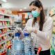woman getting water in the supermarket | Fact Check: A Blanket National Quarantine is Likely Not Legal | Featured