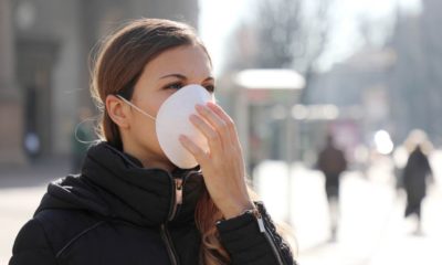 woman outside wearing a white face mask | The Head of the WHO Warns that 'The Worst' of the Coronavirus is 'Ahead of Us' | Featured