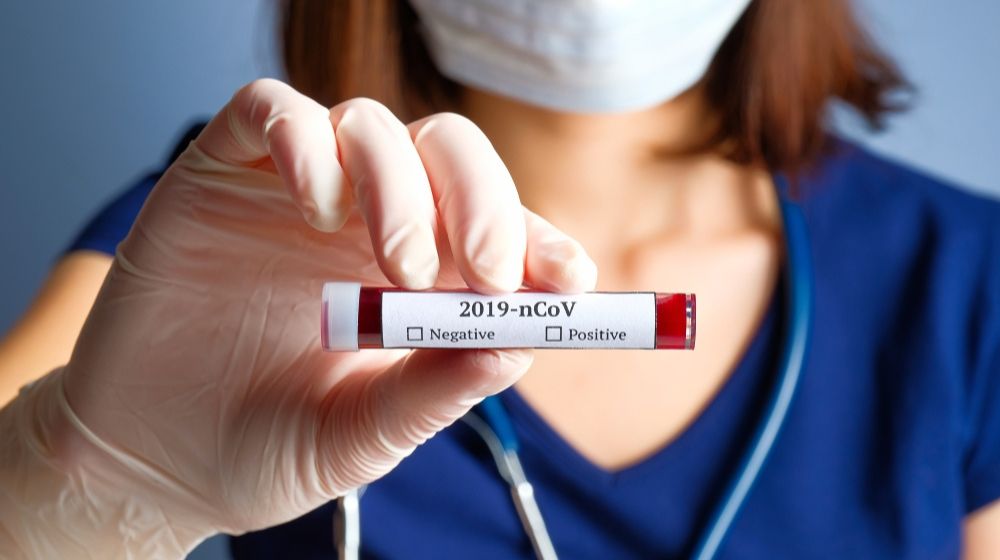 Nurse holding a test tube with blood for covid testing | Containment Efforts Show Progress as Coronavirus Curve Begin to Flatten | Featured