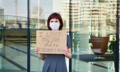 woman with mask holding i lost my job sign | U.S. Economy Lost 701,000 Jobs as Coronavirus Rages | Featured