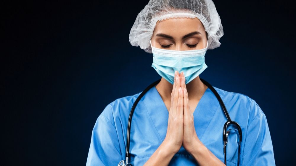 young doctor earnestly praying | Medical Staff Pray on Rooftops Amid the Coronavirus Pandemic | Featured