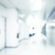 Blurred photo of the hospital alley | Woman Becomes Symptomatic After Husband Hid Coronavirus Symptoms to Visit Her at Maternity Ward | Featured
