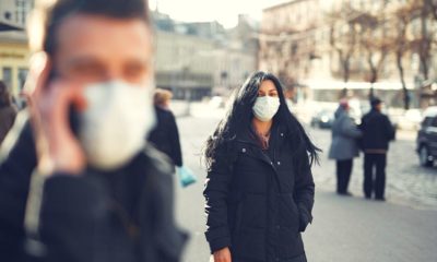 man and woman in black wearing face mask | WHO Says Rushing to Ease Coronavirus Restrictions May Cause Resurgence | Featured