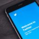 iPhone 7 Plus on Wooden Table with Open Twitter App | Twitter Apologizes for Accidentally Labeling Some Tweets as Misleading | Featured