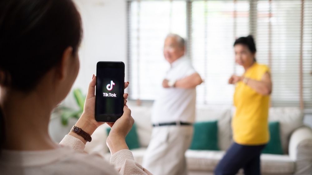 Asian Woman Using Mobile Phone Take Video Clip of Senior People Dancing to Share on TikTok Application | Trump Says US Looking Into Banning TikTok | Featured