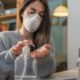 Business Woman Working from Home Wearing Protective Mask Cleaning Her Hands with Sanitizer | Majority of Americans Think Their Jobs Will Never Return to Normal | Featured