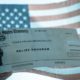 COVID-19 Economic Stimulus Check on Blurred USA Flag Background | More Than 1.3 Million Americans Filed for Unemployment Aid Last Week | Featured