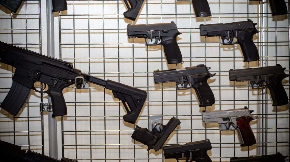 Appeals court reverses bump stock ban - Gun Wall Rack with Firearms | Number of Firearm Background Checks Reaches Highest in Years | Featured