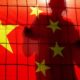 Shadow of Chinese Man Climbing a Fence Behind China Flag | U.S. Continues Crackdown On Academics’ Ties To Chinese Communists | Featured