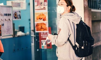 woman in hoodie wearing a mask | It’s Still Too Early to Tell If You Can Get the Coronavirus Twice | FEatured