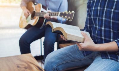 A Man Sing a Song from Hymn Book While His Friends Playing Guitar | California’s Ban on Singing in Churches Causes Outrage | Featured