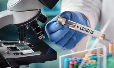 Microbiologist with a Tube of Biological Sample Contaminated by Coronavirus with Label Covid-19 | U.S. Joins 5 Official COVID-19 Vaccines Entering Phase 3 Testing | Featured