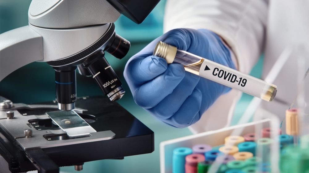 Microbiologist with a Tube of Biological Sample Contaminated by Coronavirus with Label Covid-19 | U.S. Joins 5 Official COVID-19 Vaccines Entering Phase 3 Testing | Featured