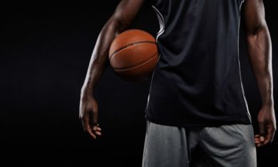 Cropped Image of Afro American Basketball Player Holding a Ball Against Dark Background | Jonathan Isaac Stands During National Anthem and Doesn’t Wear BLM Shirt; Jersey Sales Surge | Featured