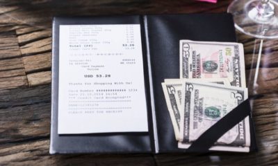 Elevated View Of Bill And Banknote On Wooden Desk | Restaurant Customers Do Not Like Being Forced to Tip Regardless Whether They Got Good or Bad Service | Featured