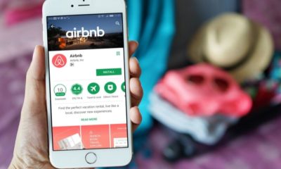 Female hand Holding Smartphone with Airbnb Application | Airbnb Launches New Pilot Restriction in the UK, France, and Spain to Reduce Unauthorized Parties | Featured