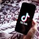 Woman holding Motorola phone with TikTok Application on the Screen | TikTok CEO Resigns Amid US Pressure to Sell Video App | Featured