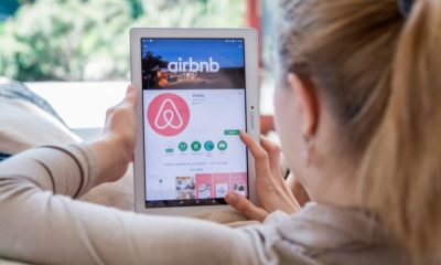 Woman is Installing Airbnb Application on Lenovo Tablet | Airbnb Announces Global Ban on Parties and Events | Featured