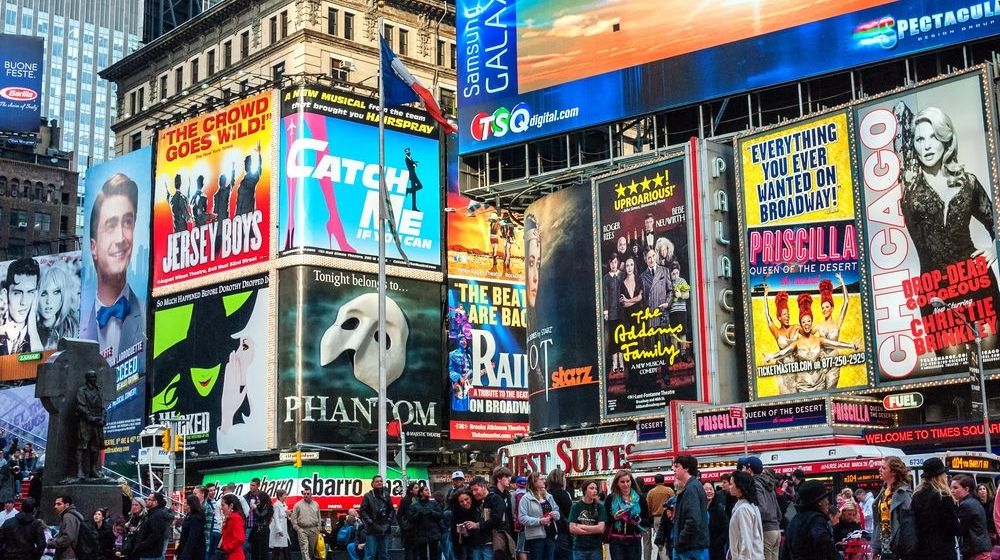 Crowds and Collage of Neon Lights at Time Square | Broadway League Announces Extension of COVID-19 Shutdown | Featured