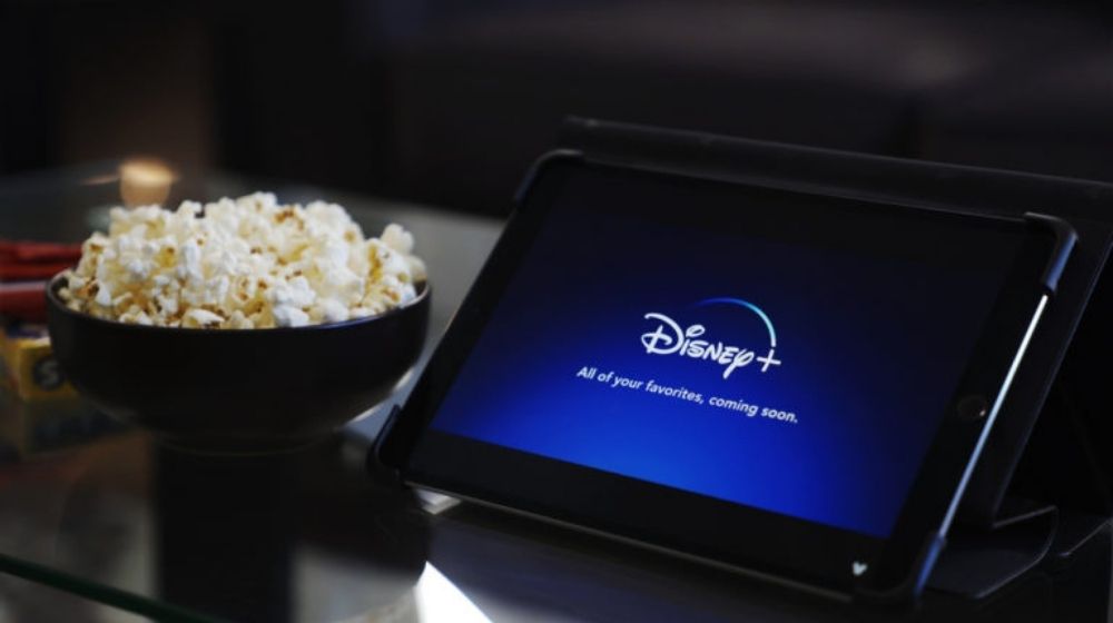 Disney Plus Logo on Tablet Screen with Popcorn | The Walt Disney Company Shifts Focus to Streaming Content; Announces Reorganization | Featured