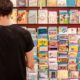 Man in Black Shirt Standing in Front of Greeting Cards Section of a Grocery Store | Greeting Card Company Hires Team of Employees Who Have Gone Through Homelessness to Design Its Cards | Featured