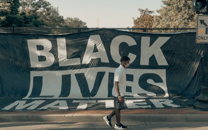 Man Walks in Front of Black Lives Matter Flag | Black Lives Matter Leaders Support Violent Riots and Looting, Biden Won’t Condemn Them