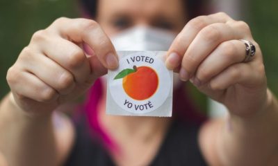 A Georgia Voter Wearing a Mask Holds Up her "I Voted" Sticker | Georgia Secretary of State: “Right Now, Georgia Remains Too Close to Call. There Will Be a Recount” | Featured