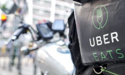 An Uber Eats Motorbike Parked on the Side of the Road | Uber Eats Accused of Discrimination for Waiving Delivery Fees for Some Black-Owned Restaurants | Featured