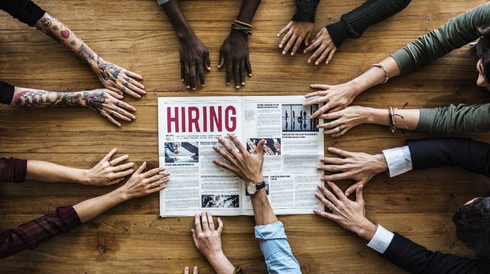 Diverse People Hands Reach Out for Hiring Newspaper Announcement-Bidens Transition Team-ss-featured