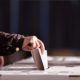 Hand of a Person Casting a Vote into the Ballot | When to Expect Election Results | Featured