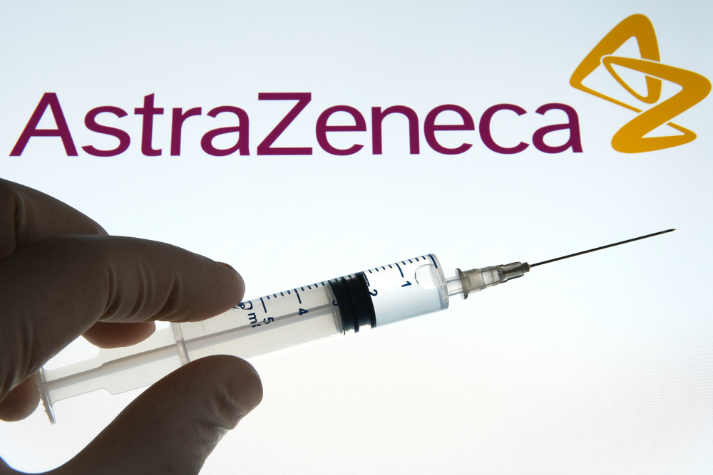 Person holding a syringe with the AstraZeneca logo in the background-AstraZeneca’s Phase 3 Data Is Expected to Be Available by Christmas-ss-featured