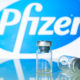 Vaccine vials in front of the Pfizer logo- Pfizer Coronavirus Vaccine Volunteer Talks About Its Side Effects-ss-Featured