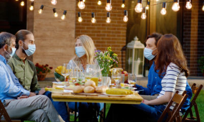 people with masks gathered around a table for a meal-Twelve Family Members Contract Coronavirus During Birthday Gathering; Infect Three Others-ss-Featured