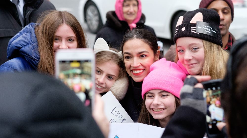 Alexandria Ocasio-Cortez (center) takes photos with fans waiting for a cab after the Women's Unity Rally in New York-Sex Work is Work-ss-featured
