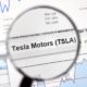 Tesla Motors stock market ticker with charts under magnifying glass-Tesla Enters S&P 500-ss-featured