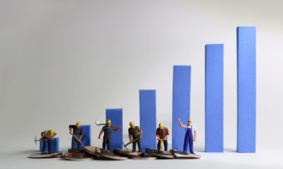 The miniature workers standing on a blue bar graph. Minimum wage increase-Raise Minimum Wage-ss-featured