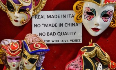 A merchant in Venice informs tourists that the quality Venetian masks are made in Italy and not made in China-Goods Made by Free Nations-ss-featured
