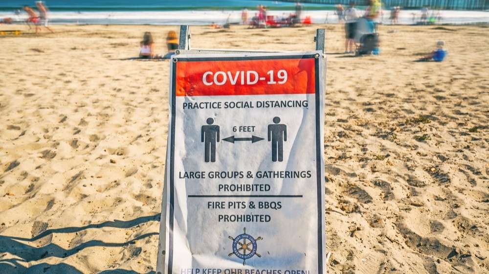 A sign reminding people of social distancing during the COVID-19 pandemic-California Drops Stay-At-Home Orders-ss-Featured