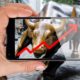 Hand pointing smartphone screen at bull of wall street in New York showing growing stock chart-Wall Street Record Highs-ss-featured