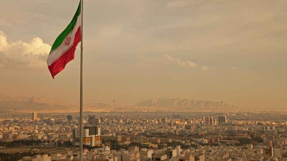 Iran flag and Tehran skyline-Iran Resumes 20% Enrichment at Fordow with U.S. Tensions Growing-ss-featured